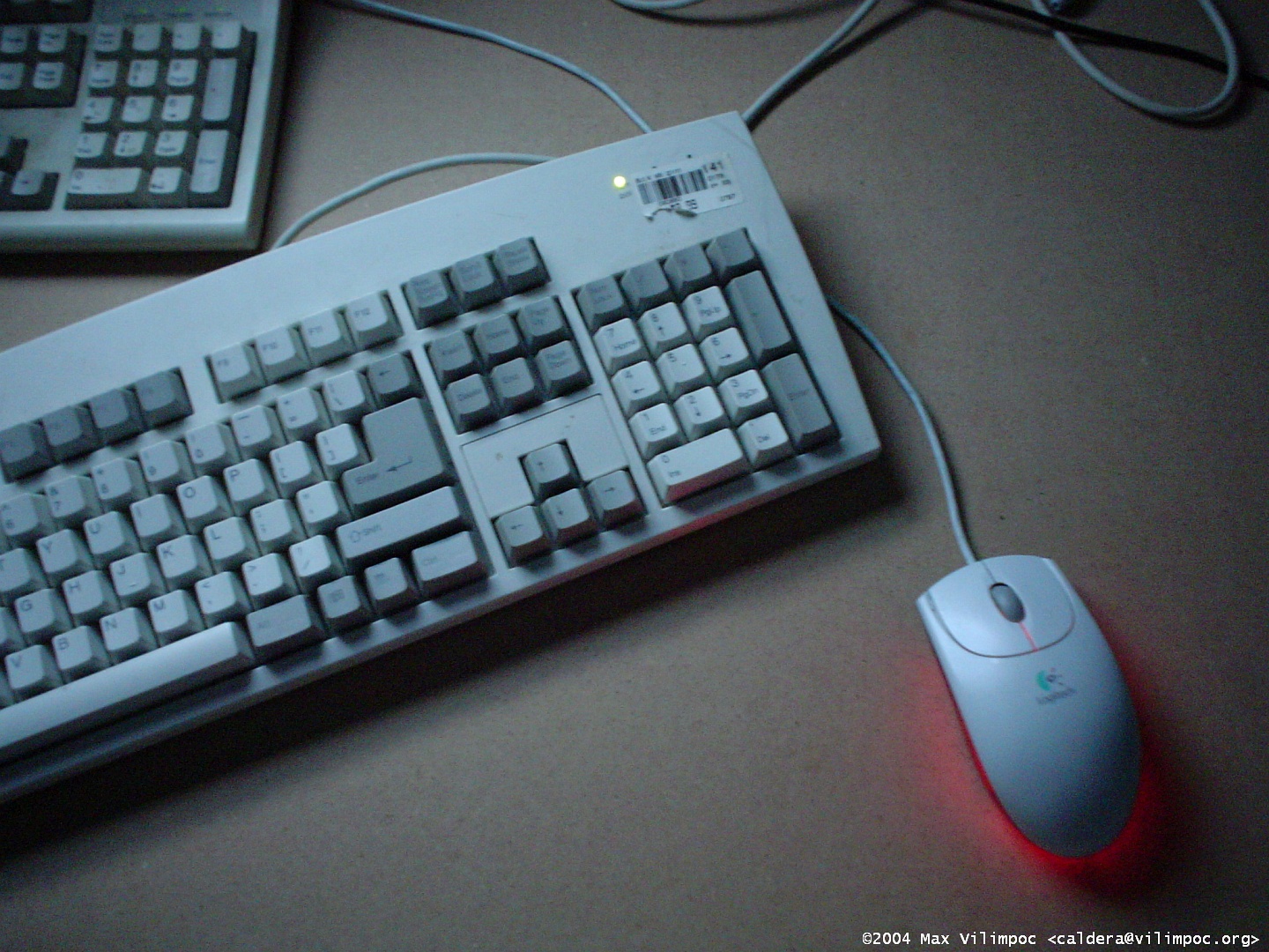 Two wire US English keyboards, both partially obscured at the left edge of the picture, and a Logitech wired mouse with the red glow of the sensor LED visible