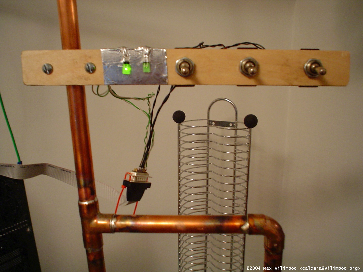 A view of the custom power, reset, and turbo single pole single throw switches mounted horizontally to a piece of wood, which is attached to the vertical stem of the computer