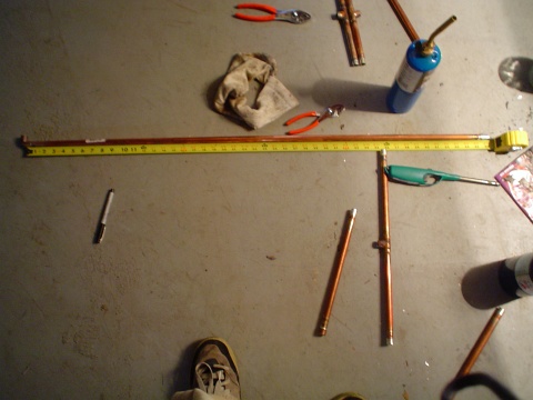 A measuring tape measuring a length of copper tubing