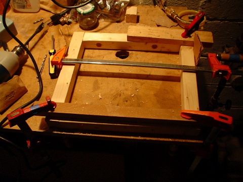 The rectangular wooden support frame being held together by long bar clamps