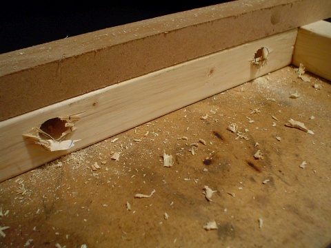 Two three quarter inch holes drilled through the wooden support frame