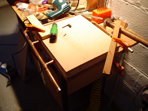 Attaching the middle density fiberboard to the wooden support frame at the basement workbench